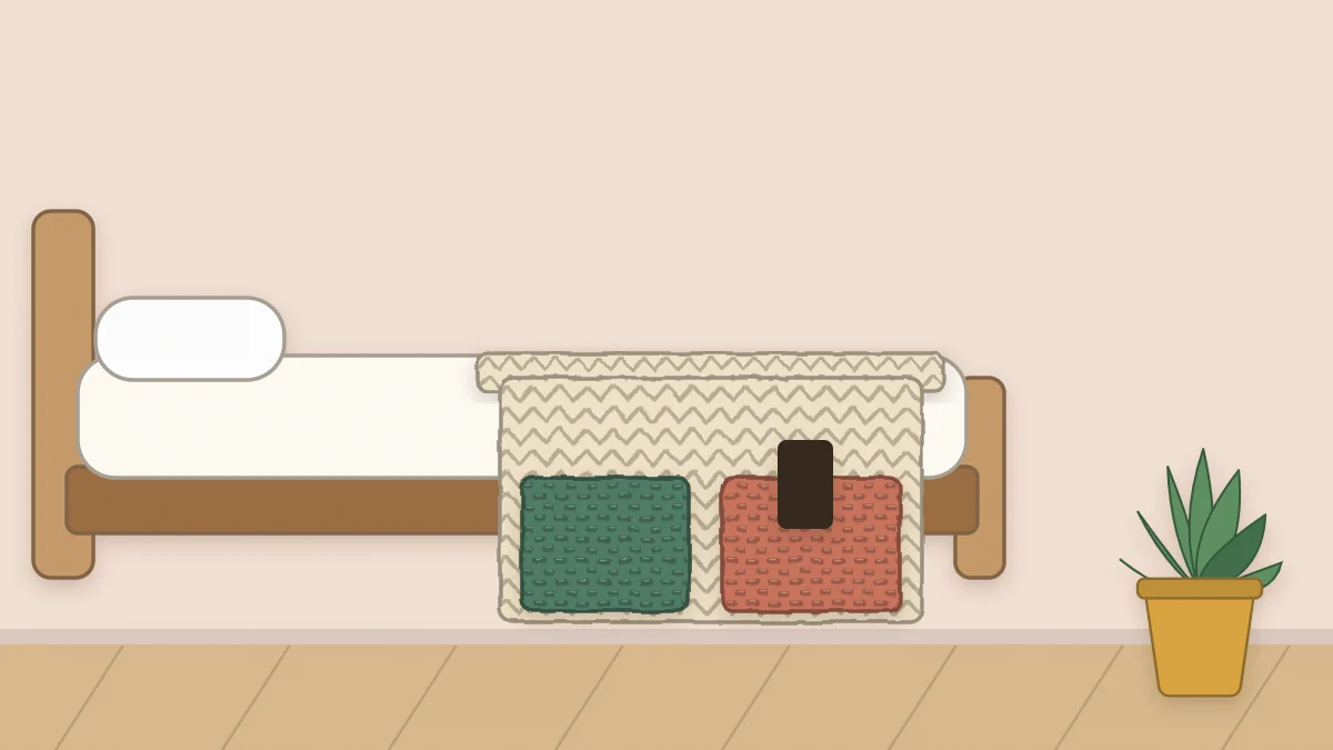 Crochet pocket organizer hanging from the side of a bed with a book in one pocket