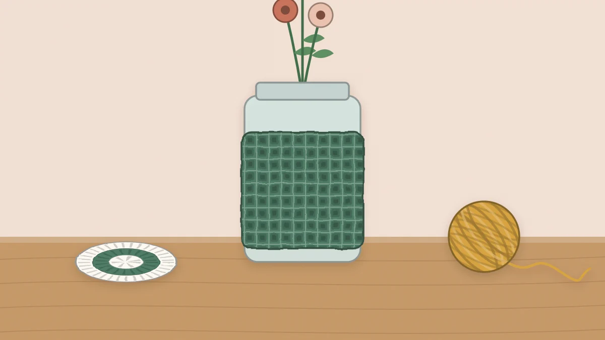 A glass jar in a textured crochet sleeve holding a few flower stems