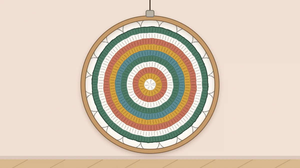 Colorful crochet mandala laced into a round hoop hanging on a wall