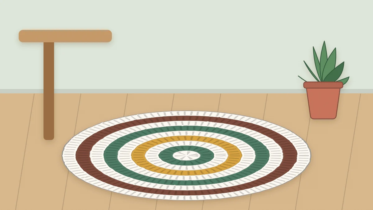 A round crochet rug with concentric rounds on a wood floor beside a chair leg and a potted plant