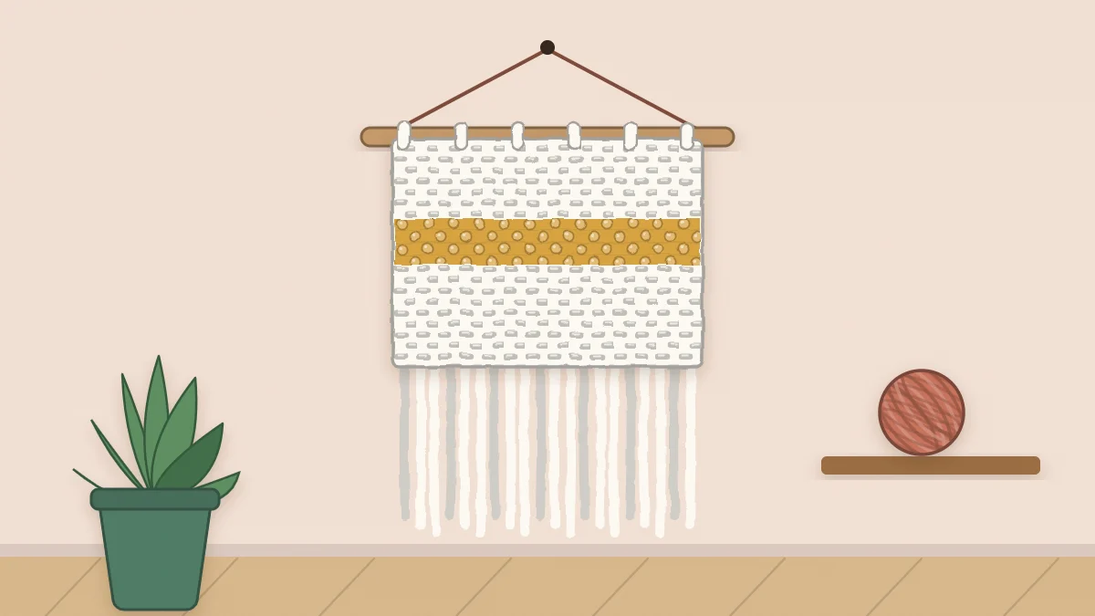 Textured crochet wall hanging on a wooden dowel with a long fringe along the bottom